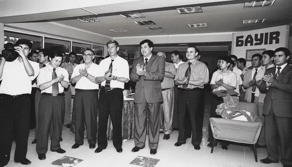 Bir guruh odamlar ofisda nishonlashmoqda, taxminan 1999 yil